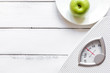 © 279photo - floor scale and apple on wooden background top view
