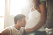 © NDABCREATIVITY - Husband kissing pregnant wife belly