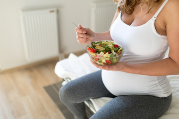 Wall Mural - Pregnant woman eating healthy salad