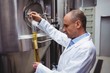 © WavebreakMediaMicro - Manufacturer examining beer at brewery