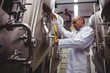 © WavebreakMediaMicro - Low angle view of manufacturer examining beer