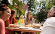 © Syda Productions - happy friends having dinner at summer garden party