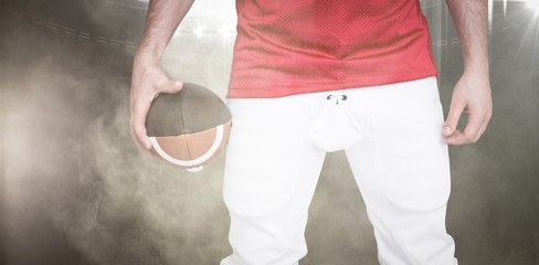 Canvas Print - Composite image of american football player holding a ball