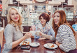 Three young women girlfriends having a coffee break. The concept of meeting friends and socializing