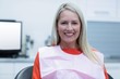 © WavebreakMediaMicro - Smiling female patient sitting on dentist chair