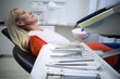 © WavebreakMediaMicro - Woman relaxing on dentist chair with dental tools on foreground