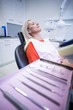 © WavebreakMediaMicro - Woman relaxing on dentist chair with dental tools on foreground