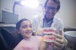 © WavebreakMediaMicro - Dentist showing model teeth to patient