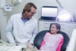 © WavebreakMediaMicro - Smiling dentist talking to young patient