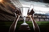 Fototapeta Sport - Composite image 3D of cropped hand of athlete holding trophy