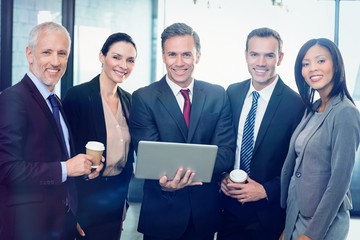 Poster - Portrait of businesspeople standing together with laptop
