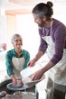 © WavebreakMediaMicro - Male potter assisting female potter while making pot