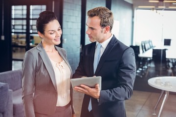 Poster - Businessman and businesswoman using digital tablet