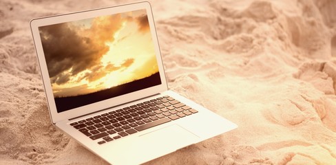 Poster - Composite image of laptop kept on sand at beach 