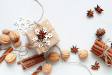 Festive Box In Beige Paper Decorated White Snowflakes Cinnamon Walnut Anise Linen Cord On Grey Table Top View 