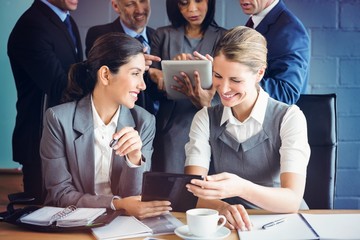 Poster - Businesswomen using digital tablet in conference room