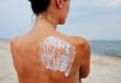 © Evgeniy Kalinovskiy - woman with suntan lotion on her shoulder that says summer 2017 against the sea