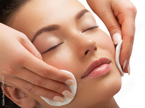 Fotografie, Obraz Portrait of happy smiling beautiful young woman cleaning skin by cotton pad