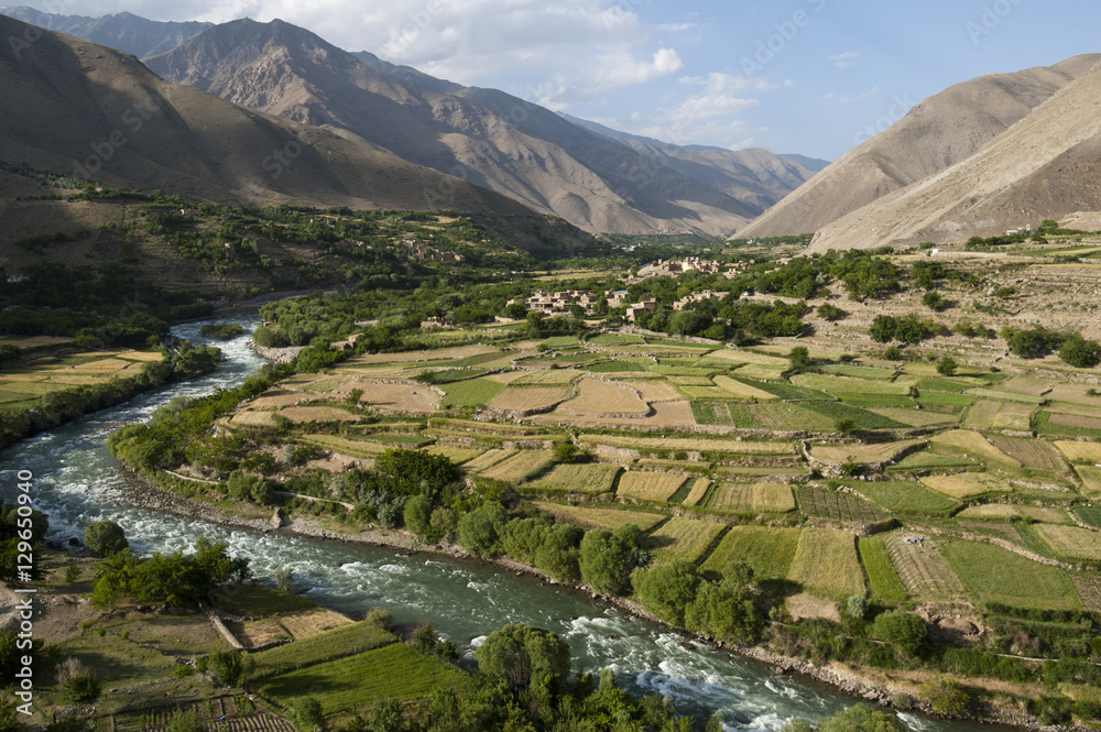 The green of the irrigated fields contrasts with the arid hills above ...