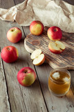 Fototapeta Kuchnia - glass of juice and apples on a cutting board