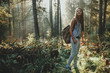 Hipster girl tourist with backpack is traveling in the woods