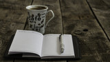 Fototapeta Psy - Kubek kawy z notesem i długopisem na drewnie