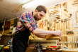 © Syda Productions - carpenter working with plane and wood at workshop