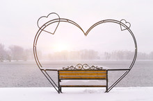 Empty Snow-covered Wrought-iron Bench In The Form Of Hearts For Couple Of Lovers In Winter Park.