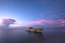 An Old Boat Wreck At The Sea Of Shore Bank With Colorful Sunset