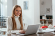 © bnenin - Beautiful young woman working on her laptop in her office