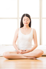 Wall Mural - asian woman meditating zen in morning beside bed