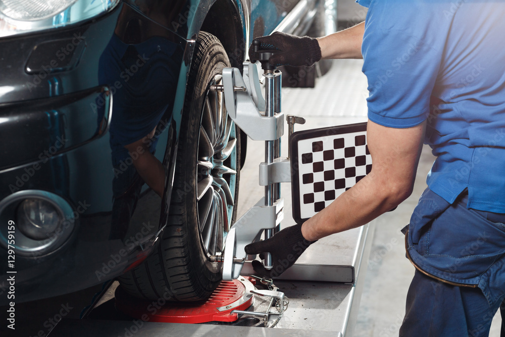 Grid sensor sets mechanic on auto. Car stand with sensors wheels for alignment camber check in workshop of Service station.