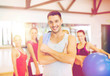 © Syda Productions - smiling man standing in front of the group in gym
