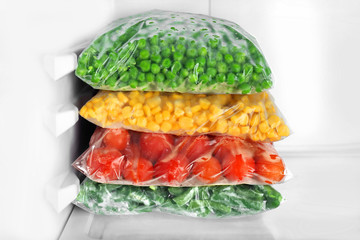 Wall Mural - Bags with frozen vegetables in refrigerator, closeup