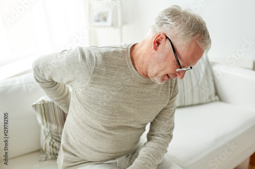 Fotografía unhappy senior man suffering from backache at home