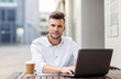 © Syda Productions - man with laptop and coffee at city cafe