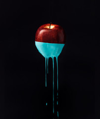 Wall Mural - Red apple with dripping blue paint. Minimal food concept.