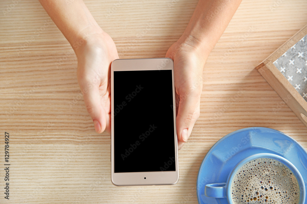 Woman with modern cellphone at table