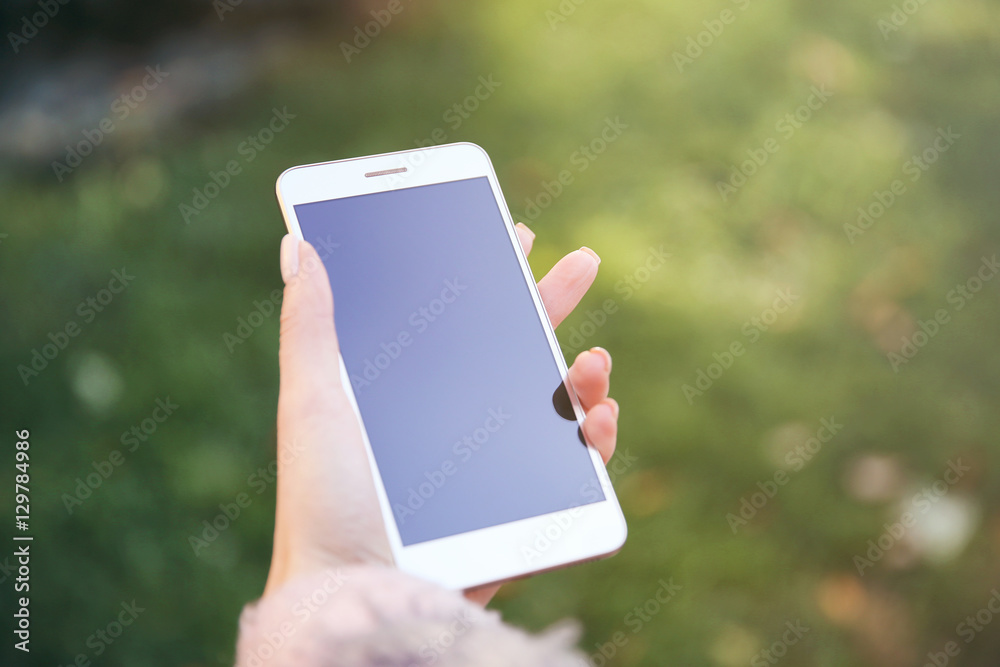Woman holding modern cellphone, outdoor