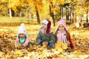 Group of happy children resting in beautiful autumn park