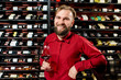 © rh2010 - Portrait of a handsome sommelier with glass of wine in front of the shelves with bottles at the luxury supermarket or restaurant