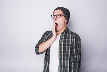 Young Man Standing On White Background And Yawning