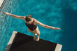 High angle view of a female swimmer ready to dive while standing at the edge of the springboard