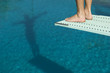 © MDBPIXS - Low section view of a male diver ready for a dive standing at the edge of the springboard
