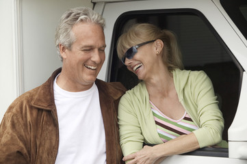 Wall Mural - Smiling mature couple next to RV