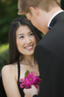 Well-dressed teenage girl receiving corsage from date outside