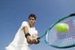 © moodboard - Low angle view of determined young man playing tennis against blue sky