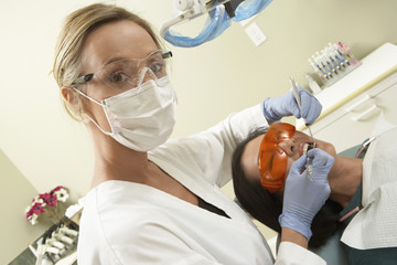 Portrait of female dentist treating patient at clinic