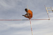 © moodboard - Low angle view of male pole vaulter clearing bar against cloudy sky