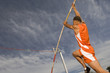 © moodboard - Male pole vaulter taking off in sports field